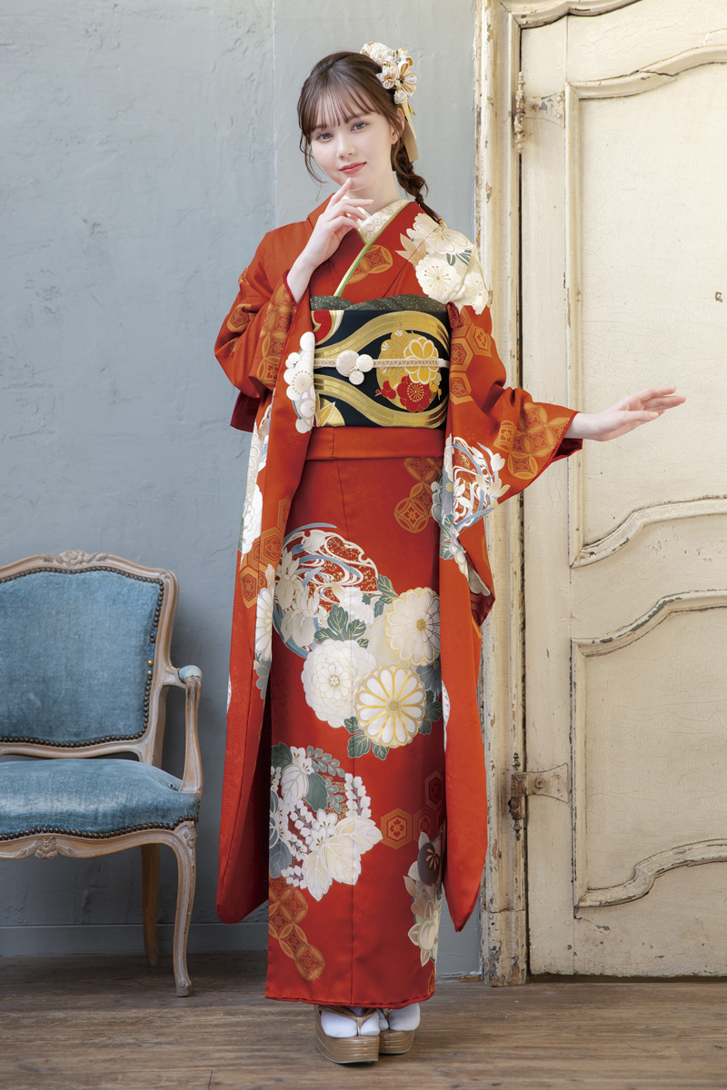 柔らかな光に映える朱赤の振袖。白や金の大きな花紋様が清楚で可憐な印象を与える、最新トレンドを取り入れた着こなし。
